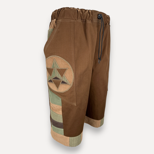 nowAwear brown twill shorts featuring a circular star patch, elastic drawstring waist, and green corduroy accents.