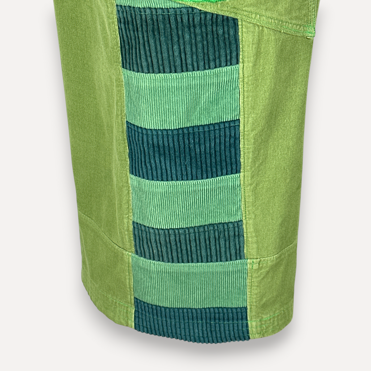 nowAwear medium green corduroy shorts featuring a vertical striped panel with alternating light and dark green tones