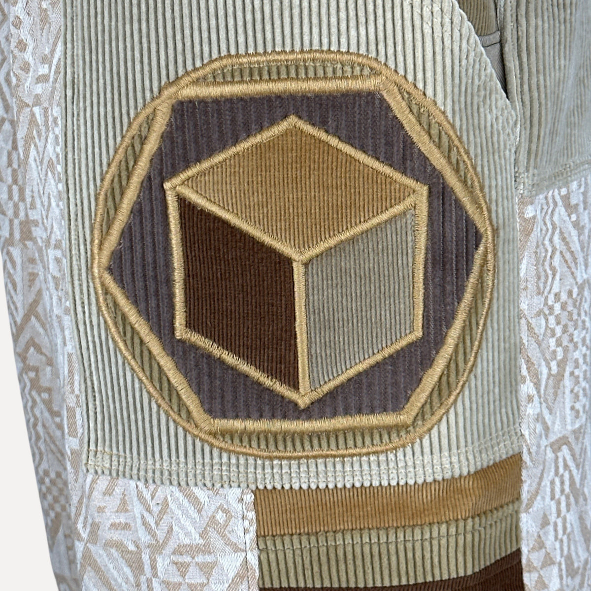 nowAwear shorts in beige corduroy featuring a geometric cube patch and patterned fabric panels
