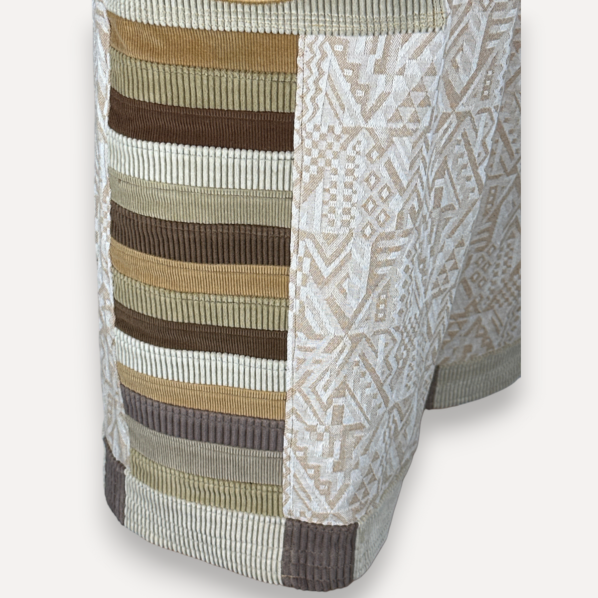 nowAwear shorts featuring a patchwork design of brown and tan corduroy stripes and cream geometric patterned fabric.