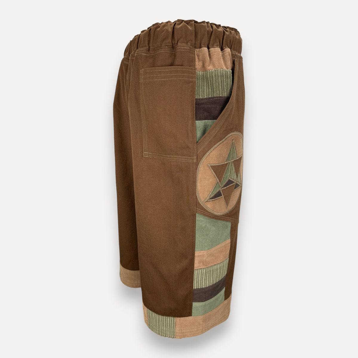 nowAwear brown twill shorts featuring a side panel with green and brown corduroy accents and a star patch detail