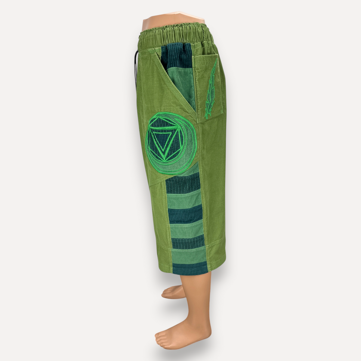 nowAwear medium green corduroy shorts featuring a circular embroidered patch and striped side panel detail