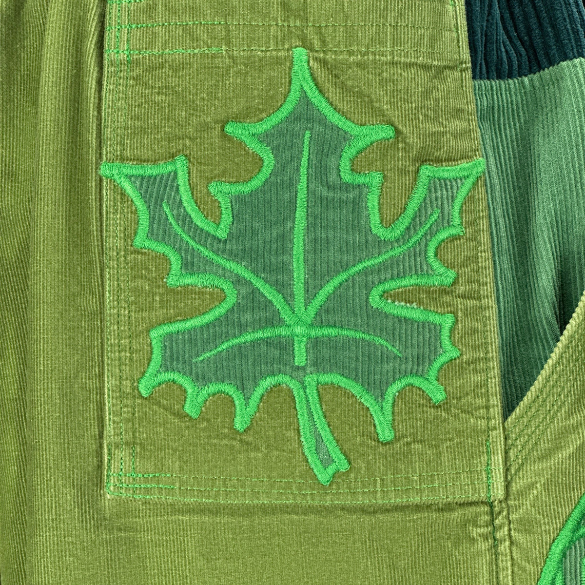 nowAwear medium green corduroy shorts featuring a detailed embroidered leaf patch on the pocket