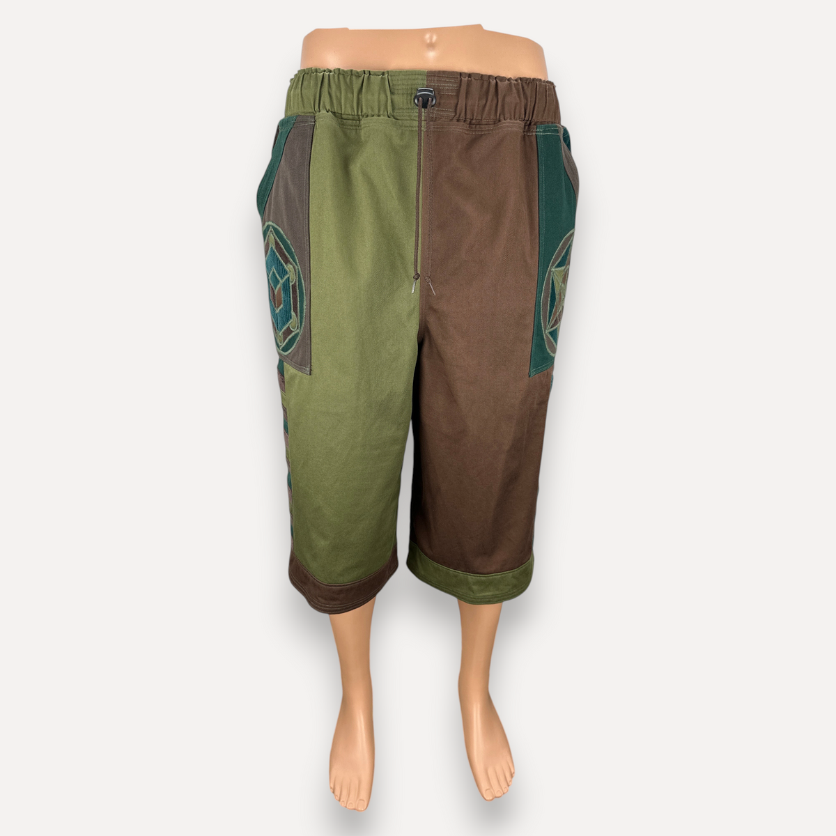 nowAwear medium brown and green color-blocked shorts with geometric side panel patterns and an elastic waistband.