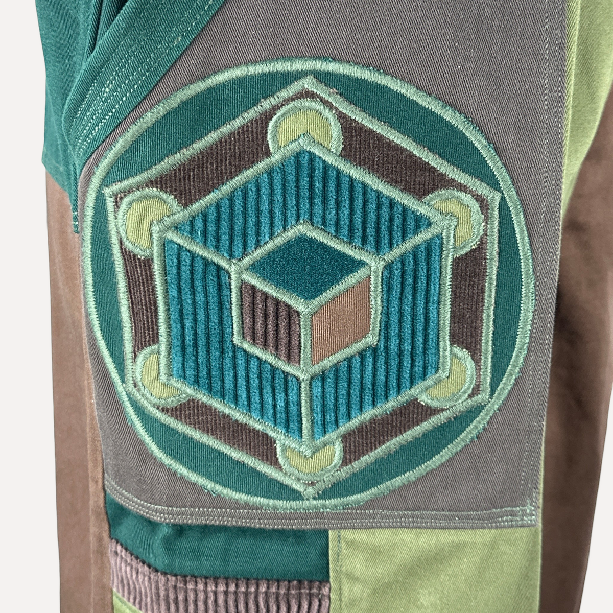 nowAwear shorts in medium brown and green featuring a detailed geometric cube embroidery patch on corduroy fabric