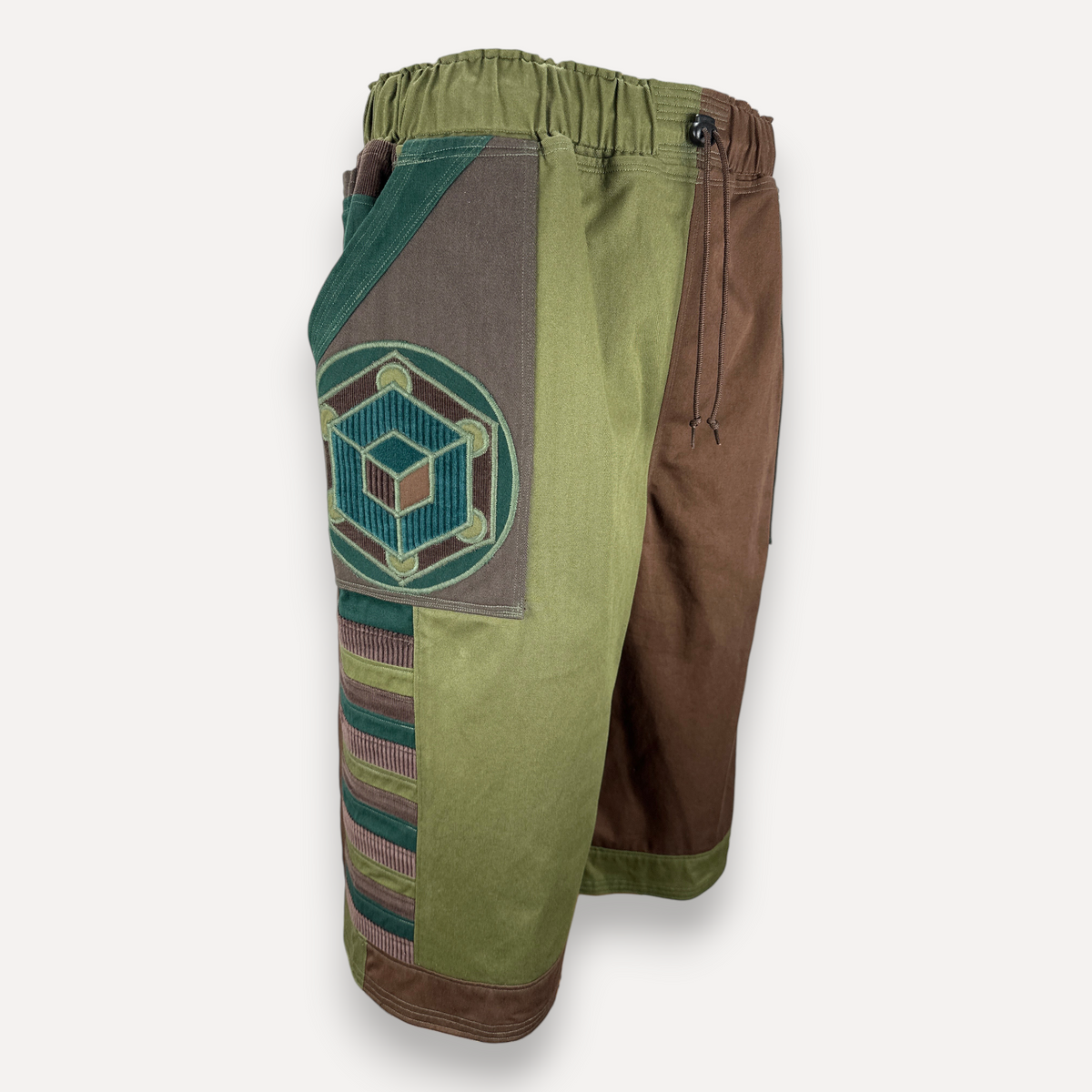 nowAwear medium brown and green shorts featuring a geometric cube patch, elastic waistband, and side panel detailing.