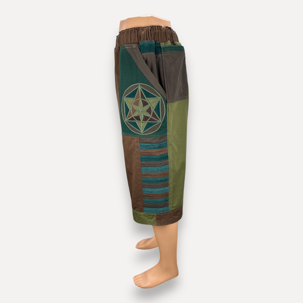 nowAwear medium brown and green patchwork shorts featuring a geometric flower of life embroidery and side pockets.