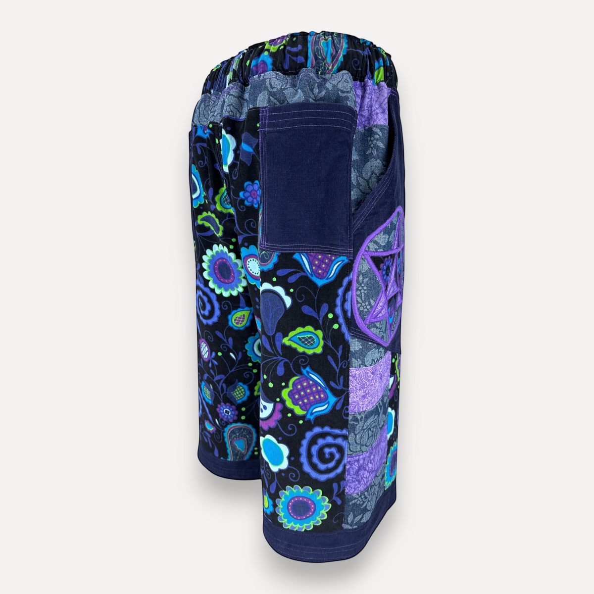 nowAwear shorts featuring a vibrant purple and blue floral pattern with patchwork corduroy pockets 