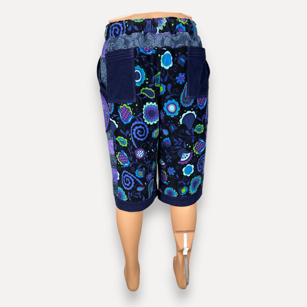 nowAwear shorts featuring a vibrant black, blue, and green floral pattern with deep blue pockets and elastic waist