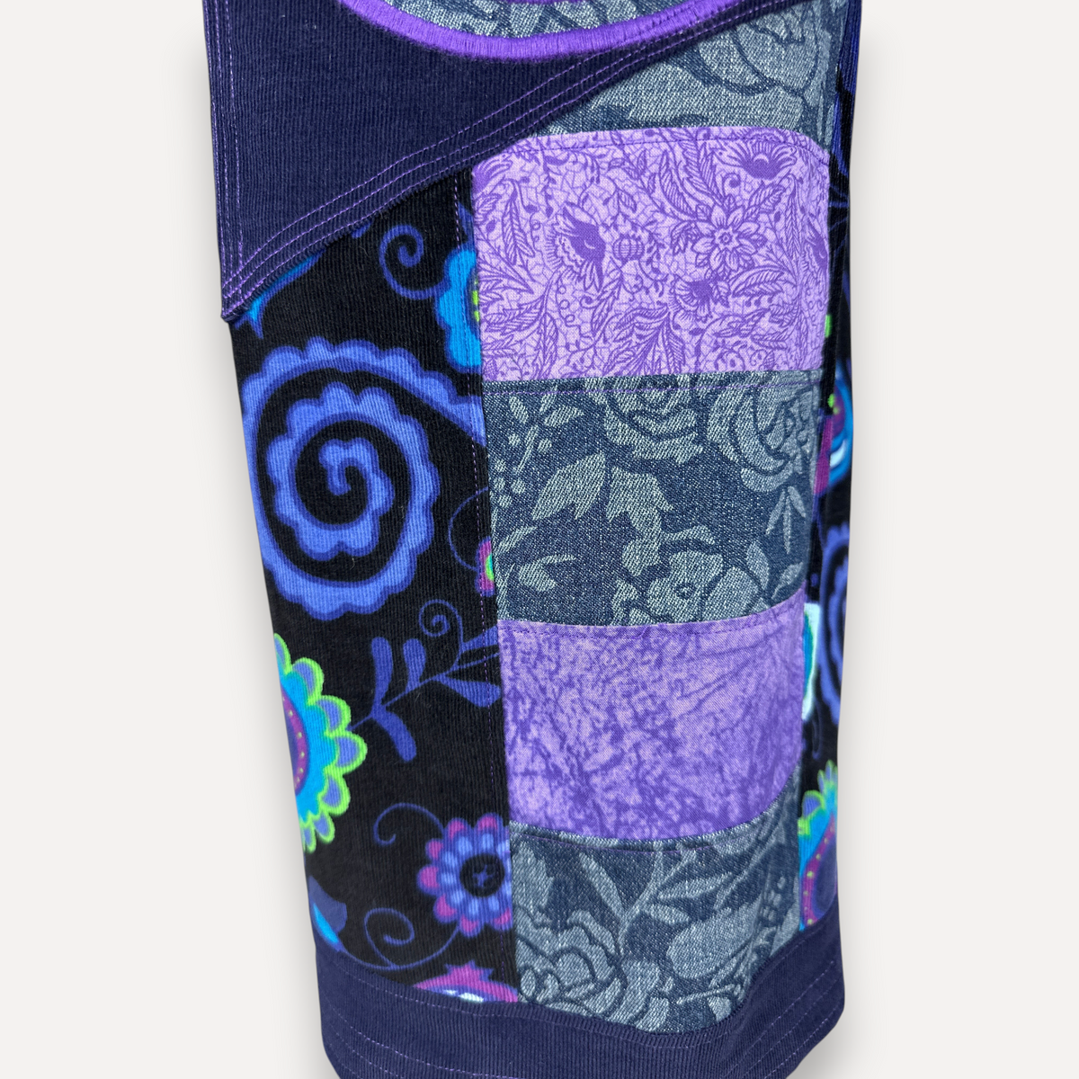 nowAwear shorts featuring a patchwork design with purple floral denim and black spiral patterned corduroy fabric.